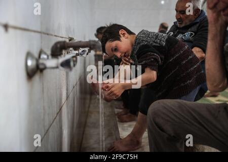 Maarrat Misrin, Syrie. 17 avril 2021. Les musulmans syriens exécutent le rituel de nettoyage « Wudu » alors qu'ils se préparent à lire le Coran et prient à la mosquée de la ville de Maarrat Misrin pendant le mois musulman de jeûne Saint du Ramadan. Credit: Aras Alkharboutli/dpa/Alamy Live News Banque D'Images