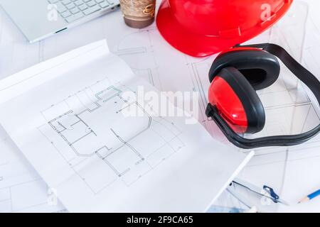 Gros plan des plans de construction avec cache-oreilles de sécurité et casque le haut Banque D'Images