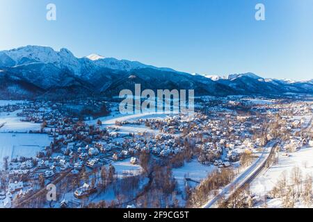 Matin froid au-dessus de la ville de Zakopane en Pologne couverte de neige avec des montagnes en arrière-plan. Antenne. Vidéos 4k de haute qualité Banque D'Images