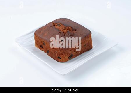 Gâteau de prune, délicieux gâteau de christmus fait maison en utilisant des raisins secs, noix de cajou et fruits secs placés sur une table blanche avec fond blanc, je Banque D'Images