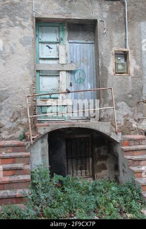 Porte fermée abandonnée, avec escalier, balcon, mains courantes, boîte à fusibles et signe de paix sur une porte en bois Banque D'Images