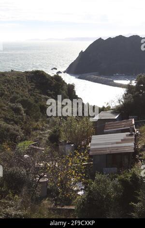 Cabanes en fonte ondulée dans une vallée avec vue sur l'océan Banque D'Images
