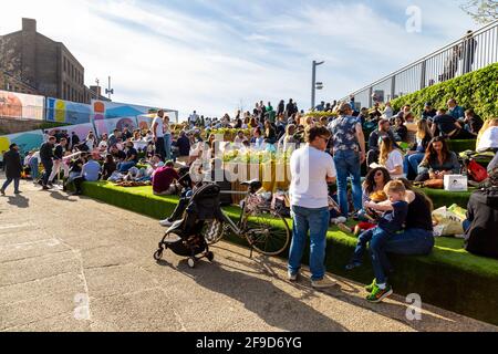 17 avril 2021 - Londres, Royaume-Uni, des gens assis le long du canal Regents près de Granary Square, Kings Cross lors d'un week-end ensoleillé après avoir assouplit le blocage de la pandémie de coronavirus Banque D'Images