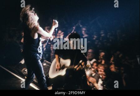 INXS en action: Le chanteur Michael Hutchence et le membre du groupe Kirk Pengilly avec la guitare acoustique pendant le spectacle de Munich au Deutsches Museum en 1988. Banque D'Images