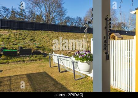Magnifique vue sur le panier suspendu sur pilier blanc avec pansies pourpres blanches. Suède. Banque D'Images