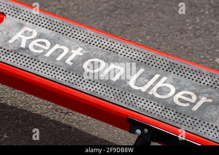 Bucarest, Roumanie - 13 avril 2021: Louer sur le message Uber est vu sur un scooter électrique Lime qui sont garés sur un trottoir. La chaux peut être louée par Banque D'Images