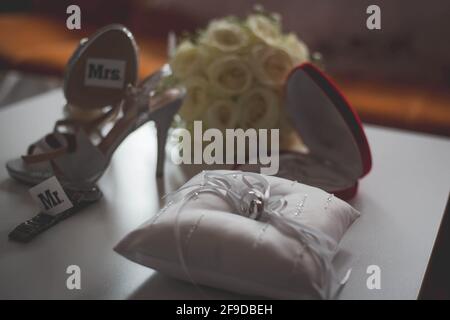 Gros plan de chaussures de mariée, montre-bracelet, anneaux, collier, et un bouquet de fleurs Banque D'Images