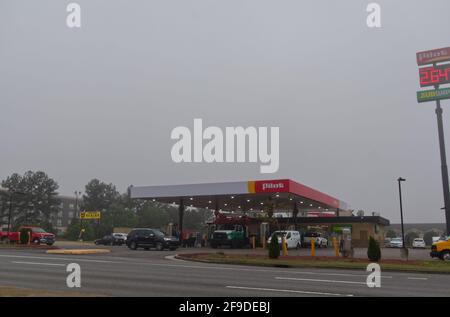 Augusta, GA USA - 03 31 21: Station-service pilote avec des gens et des voitures vue sur la rue affiche de prix de l'essence un matin brumeux Banque D'Images