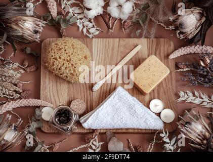 Composition avec fleurs sauvages sèches, produits de soins personnels sur un élément en bois au centre. Banque D'Images