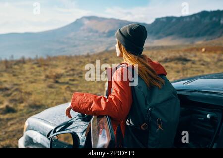 une femme voyage dans la nature avec un sac à dos et près du voiture Banque D'Images