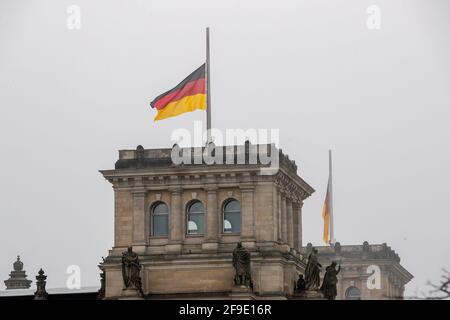 Berlin, Allemagne. 18 avril 2021. Le drapeau allemand au sommet du bâtiment du Reichstag vole en Berne à l'occasion du mémorial central pour ceux qui sont morts dans la pandémie de Corona en Allemagne. Credit: Christoph Soeder/dpa/Alay Live News Banque D'Images