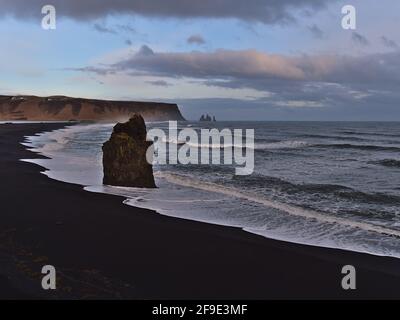 Vue imprenable sur le paysage volcanique avec plage noire Reynisfjara près de la route 1 sur la côte sud de l'Islande avec les célèbres formations rocheuses Arnardrangur. Banque D'Images