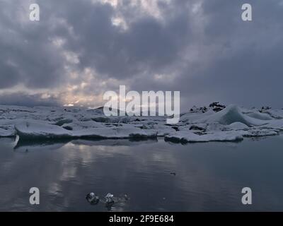 Belle vue sur le lac glaciaire Jökulsárlón, situé dans le sud de l'Islande dans le parc national de Vatnajökull, avec des icebergs flottants reflétés dans l'eau calme. Banque D'Images