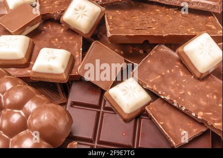 gros plan sur le chocolat. Vue de dessus de divers délicieux morceaux de chocolat arrière-plan. Morceaux de barre de chocolat avec des éclats de chocolat Banque D'Images