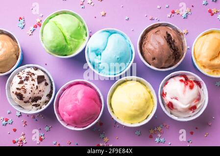 Assortiment de crèmes glacées. Divers glaces ou glaces sur fond violet gros plan. Yaourt glacé dans de petites tasses - dessert d'été sain. Banque D'Images