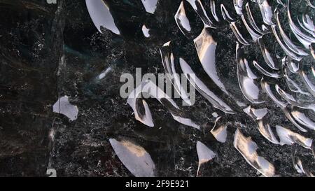 Formations de glace bizarres avec une surface glacée claire et lisse et des réflexions dans le mur de la grotte de glace de saphir dans le glacier de Breiðamerkurjökull, Vatnajökull. Banque D'Images