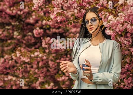 Effet longue durée. Marque de parfumerie. Composés aromatiques. Parfum de luxe. Une femme tendance tient un flacon de parfum. Arôme de fleur de cerisier. Parfum féminin Banque D'Images