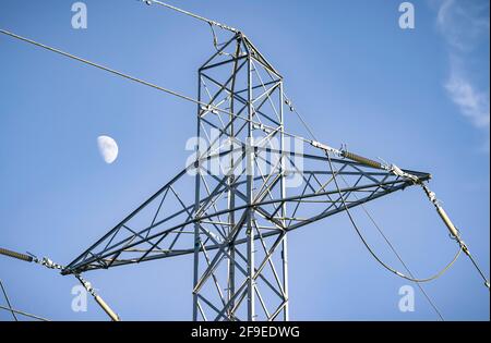 Détail de pylône d'électricité avec la lune contre un ciel bleu, représentant le réseau national britannique et l'alimentation électrique Banque D'Images