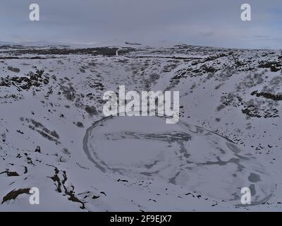 Vue sur le lac de cratère volcanique gelé Kerið (également Kerid, Kerith) à Grímsnes, Islande, partie du cercle d'or, avec des pentes enneigées en hiver. Banque D'Images