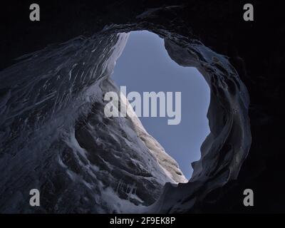 Vue à angle bas d'un grand trou de moulin dans le plafond de la grotte de glace de Sapphire, située dans le glacier de Breiðamerkurjökull, Vatnajökull, Islande. Banque D'Images