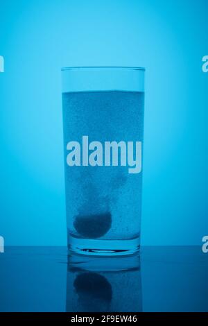 Le comprimé effervescent se dissout dans un verre d'eau Banque D'Images