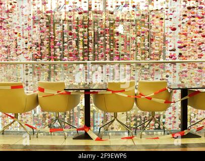 Verrouillage gastronomique, terrasse de restaurant fermée avec chaises et tables vides bloquées avec ruban d'avertissement en raison de l'épidémie de couronne, image symbolique Banque D'Images