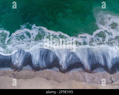 Vue aérienne des vagues turquoise atteignant le rivage Banque D'Images