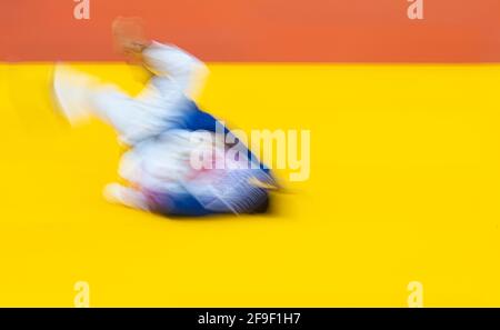 Deux judo combattants en uniforme blanc et bleu. Filtre de mouvement flou. Concept de sport professionnel Banque D'Images