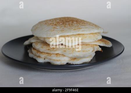 Crêpes de riz faites maison à base de pâte de riz fermentée et de noix de coco râpée. Le plat de petit déjeuner préféré du Kerala appelé Kallappam. Prise de vue sur fond blanc Banque D'Images