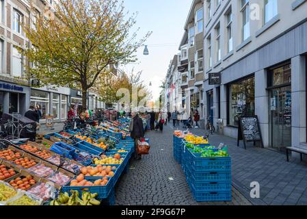 Vue ensoleillée en plein air, stands de nourriture, magasins, café et restaurant dans la rue piétonne en direction de Markt Maastricht autour de Stadhuis van Maastricht, hôtel de ville. Banque D'Images