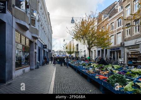 Vue ensoleillée en plein air, stands de nourriture, magasins, café et restaurant dans la rue piétonne en direction de Markt Maastricht autour de Stadhuis van Maastricht, hôtel de ville. Banque D'Images