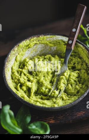 Purée de sauce avocat dans un bol sur une table en bois sombre arrière-plan Banque D'Images