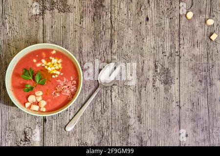 Zénith vue d'un bol de gazpacho avec des compléments et une cuillère à droite. Concept de nourriture méditerranéenne, saine. Banque D'Images