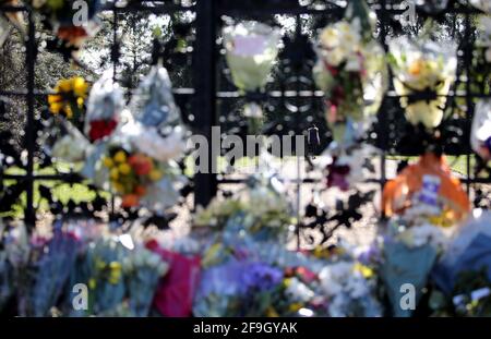 Sandringham, Royaume-Uni. 17 avril 2021. Une personne vue à travers les portes fleuries Norwich marche en direction de Sandringham House à Norfolk, le jour des funérailles du prince Philip, duc d'Édimbourg, le 17 avril 2021 crédit: Paul Marriott/Alamy Live News Banque D'Images