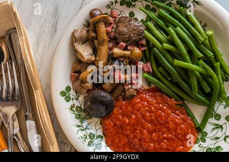 Une photo aérienne d'un repas végétarien composé de vert haricots et champignons à la tomate sur une table rustique en bois Banque D'Images