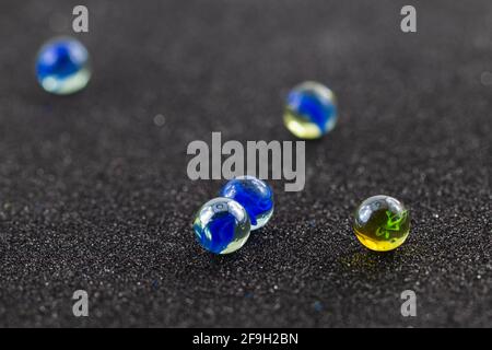 billes de verre de couleur dispersée sur fond noir Banque D'Images