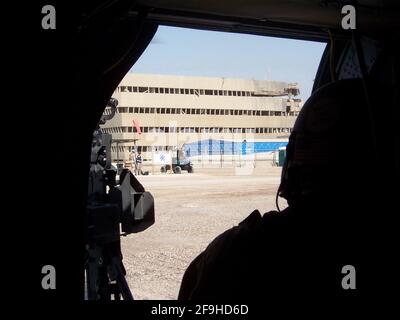 Silhouette d'un tireur à porte dans un hélicoptère Blackhawk à une base opérationnelle avancée à Bagdad, en Irak Banque D'Images