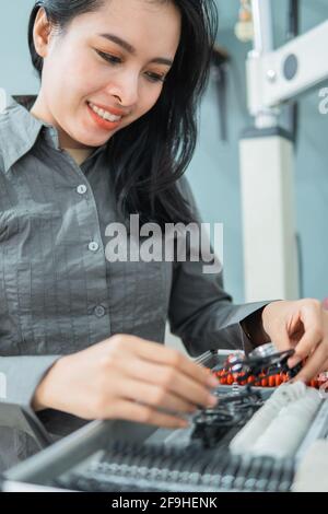 une femme médecin tenant une aide de mesure de test oculaire dans une clinique oculaire Banque D'Images