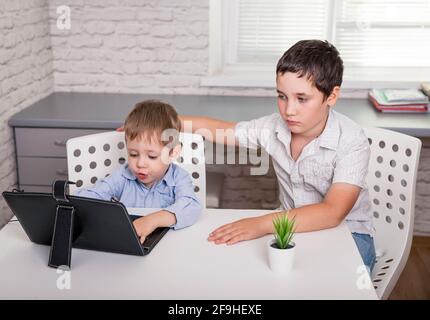 Enfants utilisant des gadgets pour étudier. Éducation enseignement à distance pour les enfants. Banque D'Images