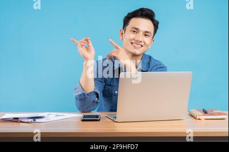 Image du jeune buisnessman asiatique sur fond bleu Banque D'Images