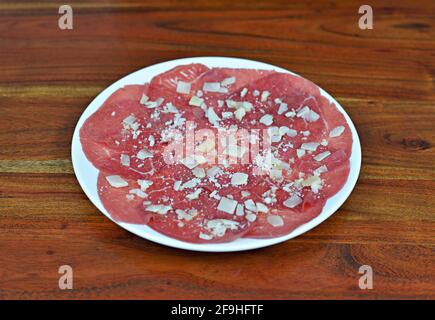 Assiette de carpaccio de bœuf au parmesan sur un bois tableau Banque D'Images