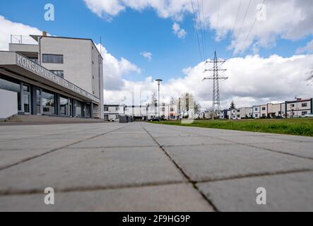 PRODUCTION - 14 avril 2021, Saxe-Anhalt, Dessau-Roßlau : pylône électrique, tel que conçu par Walter Gropius, s'élève à côté du bâtiment Konsum dans le domaine de Bauhaus à Dessau-Törten. La Fondation Bauhaus Dessau consacre son thème annuel pour 2021 à l'infrastructure et à la modernité. Que ce soit des pylônes d'électricité, des appareils de théâtre ou des bâtiments fonctionnels comme le bureau de l'emploi - l'infrastructure est encore considérée comme un thème central de la société pour le Bauhaus aujourd'hui. Des expositions, des conférences et des discussions sont prévues - en rapport avec corona aussi virtuellement. Photo: Hendrik Schmidt/dpa-Z Banque D'Images