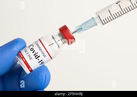 Médecin tenant le vaccin du coronavirus et la seringue utilisée pour prévenir l'infection par le COVID-19. Banque D'Images