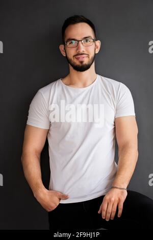 Portrait d'un jeune homme beau dans une chemise noire en studio Banque D'Images