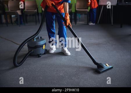 Femme de ménage utilisant un aspirateur-traîneau Banque D'Images