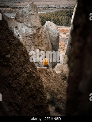 Vue arrière d'une fille solitaire assise sur le rocher admirez les formations rocheuses très vives Banque D'Images