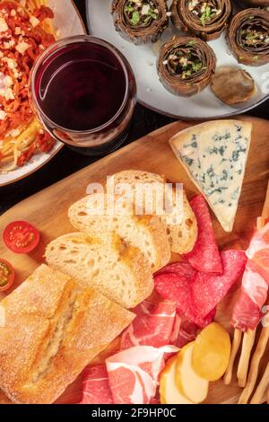 Antipasti italiens avec vin, tiré d'en haut. Pain, fromage, jambon, artichauts Banque D'Images