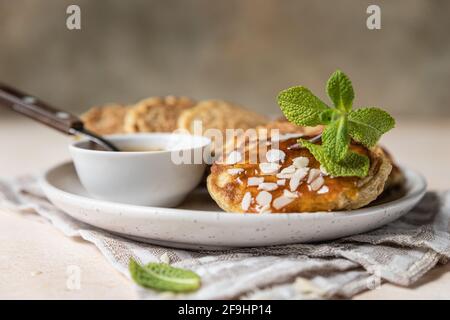 Crêpes d'avoine saines avec confiture, noix et menthe sur plaque en céramique. Repas de petit-déjeuner végétalien. Mise au point sélective. Banque D'Images