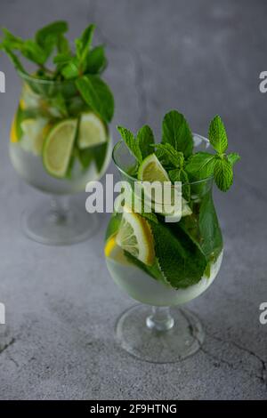 Cocktail mojito rafraîchissant à la menthe d'été avec rhum et glace sur fond gris. Cocktail Mojito sur table en pierre. Verre haut vitreux pour les boissons Banque D'Images