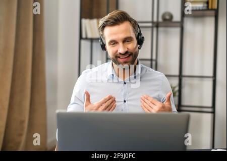 Positif concentré millennais slaves de type portant des écouteurs, à l'écoute du client tout en planifiant une stratégie de secours, de jeunes hommes d'affaires focalisés prend part à une conférence en ligne éducative Banque D'Images